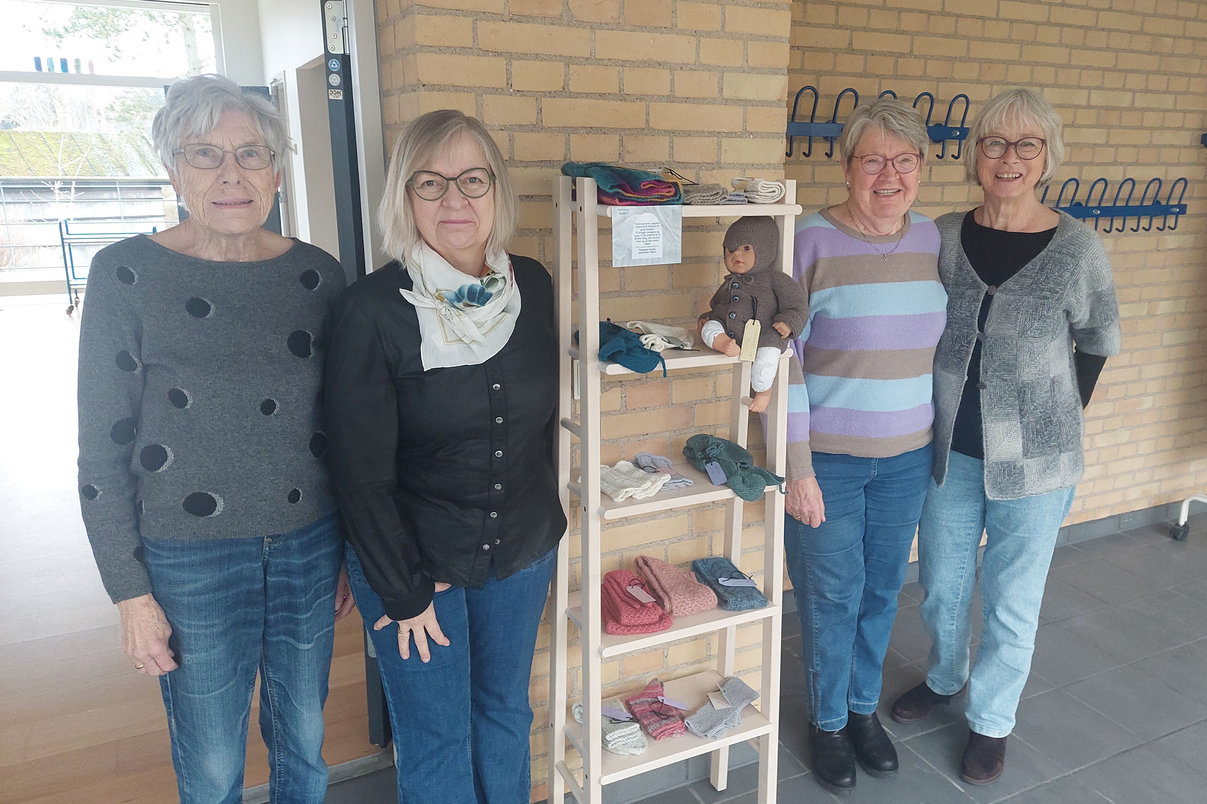 Fire kvinder viser deres håndarbejde frem